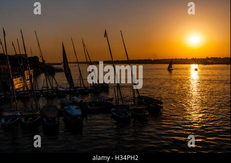 Luxor, Ägypten. Die Sonne geht über dem Nil. Feluken am Ostufer. Stockfoto