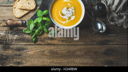 Kürbis Cremesuppe in Schüssel mit frischem Basilikum und Gewürzen Stockfoto