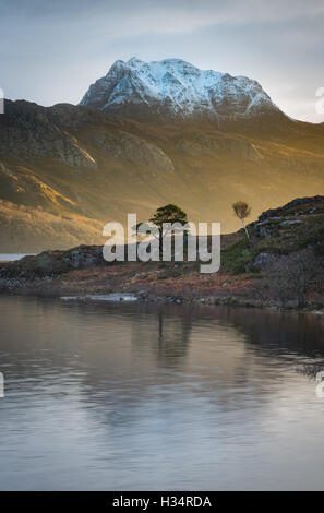 Platzen der frühen Morgensonne auf Schnee bedeckt Slioch, spiegelt sich in Loch Maree, Schottisches Hochland, Schottland Stockfoto