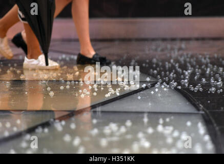 Peking, China. 4. Oktober 2016. Die Menschen gehen über Sanlitun Geschäftsstraße nach einem Niederschlag in Peking, Hauptstadt von China, 4. Oktober 2016. © Li He/Xinhua/Alamy Live-Nachrichten Stockfoto