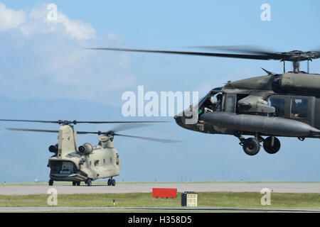 Soto Cano Luftwaffenstützpunkt, Honduras. 4. Oktober 2016. US-Armee HH - 60L Blackhawk und CH-47 Chinook Hubschrauber hebt ab auf dem Weg zum Grand Cayman Island, bei Hilfsmaßnahmen nach der Nachmahd des Hurrikans Matthäus 4. Oktober 2016 in Soto Cano Air Base, Honduras zu unterstützen. Hurrikan-Matthew war ein Sturm der Kategorie 4, die in der zentralen Karibik knallte Sachschaden verursacht. Bildnachweis: Planetpix/Alamy Live-Nachrichten Stockfoto