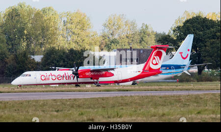 Eine Air-Berlin-Bombardier und eine Tuifly Boeing 737-800 gesehen auf dem Rollfeld des Flughafens in Hannover, Deutschland, 5. Oktober 2016.  Flüge Fluggesellschaft Etihad und Tourismus Unternehmen Tui angekündigt, dass sie planen, ein neues Wagnis bieten Urlaub Teile von Air Berlin und Tuifly verschmelzen. Foto: JULIAN STRATENSCHULTE/dpa Stockfoto