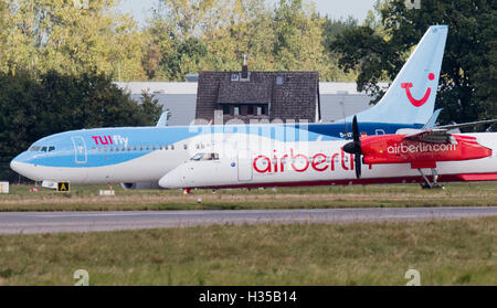 Eine Air-Berlin-Bombardier und eine Tuifly Boeing 737-800 gesehen auf dem Rollfeld des Flughafens in Hannover, Deutschland, 5. Oktober 2016.  Flüge Fluggesellschaft Etihad und Tourismus Unternehmen Tui angekündigt, dass sie planen, ein neues Wagnis bieten Urlaub Teile von Air Berlin und Tuifly verschmelzen. Foto: JULIAN STRATENSCHULTE/dpa Stockfoto