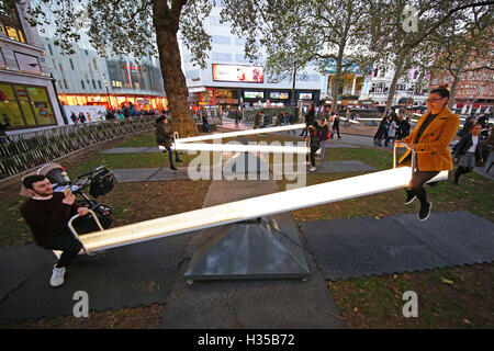 London, UK. 5. Oktober 2016. Menschen spielen auf Impuls, ein Meer von Gesang Wippen Kunstinstallation in Leicester Square Gardens in London. Die 15 Wippen sind ausgestattet mit LED Beleuchtung, Beleuchtung und Lautsprecher, die durch Bewegung aktiviert und aktivieren, wenn die Leute die Wippen. Bildnachweis: Paul Brown/Alamy Live-Nachrichten Stockfoto