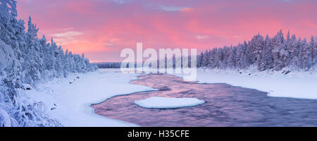 Eine schnelle in einem Fluss in eine winterliche Landschaft. Fotografiert an der Äijäkoski-Stromschnellen im Fluss Muonionjoki im finnischen Lappland im su Stockfoto