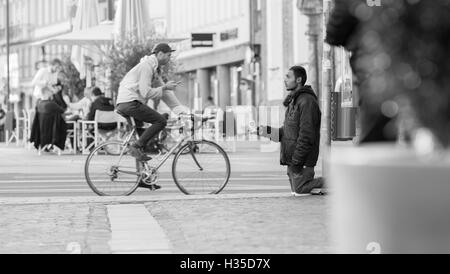 INNSBRUCK, Österreich – 1. November 2015: Flüchtling betteln um Hilfe in den Straßen von Innsbruck mit Menschen zu Fuß durch. Stockfoto