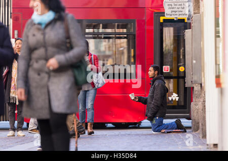 INNSBRUCK, Österreich – 1. November 2015: Flüchtling betteln um Hilfe in den Straßen von Innsbruck mit Menschen zu Fuß durch. Stockfoto