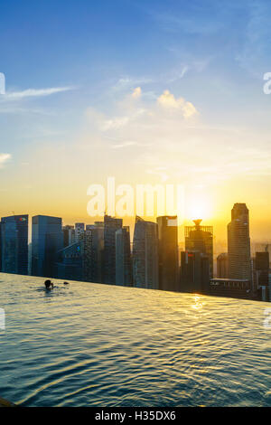 Infinity-Pool auf dem Dach des das Marina Bay Sands Hotel mit spektakulärem Blick über die Skyline von Singapur bei Sonnenuntergang, Singapur Stockfoto