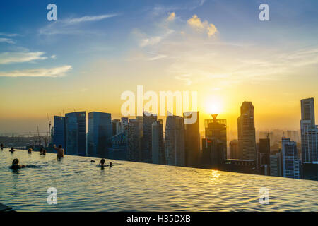 Infinity-Pool auf dem Dach des das Marina Bay Sands Hotel mit spektakulärem Blick über die Skyline von Singapur bei Sonnenuntergang, Singapur Stockfoto