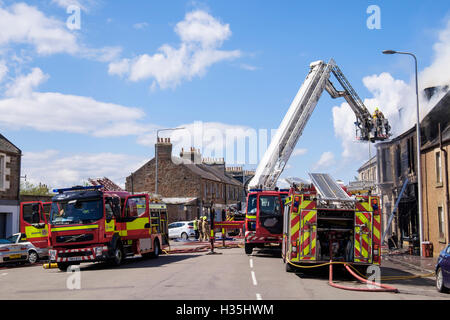 Feuerwehrleute des Scottish Fire and Rescue Service eine Leiter hoch, die ein brennendes Gebäude in Angriff nimmt. Elie und Earlsferry Fife Scotland Großbritannien Stockfoto