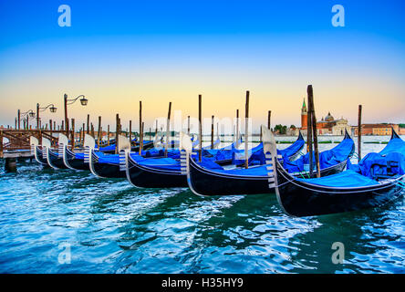 Venedig, Gondeln oder Gondeln auf einem blauen Sonnenuntergang Dämmerung und San Giorgio Maggiore Kirche Wahrzeichen auf Hintergrund. Italien, Europa. Stockfoto