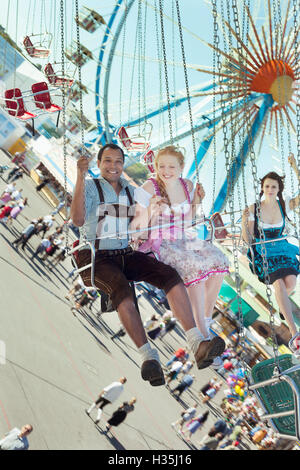 Paare, die Spaß auf Kette Karussell Ketten-Karussell auf dem Oktoberfest Stockfoto