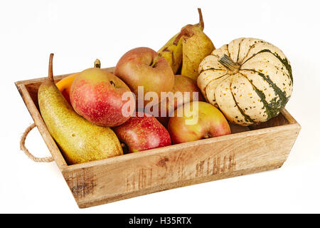 Isolierte Korb voller Herbstfrüchte mit Äpfeln, Birnen und Kürbis Stockfoto