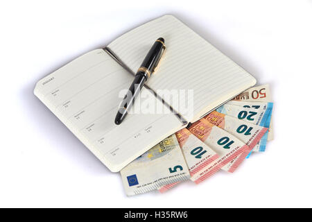 Geld verdienen mit dem Schreiben auf Geld Banknoten symbolisierten mit Stift und Notizbuch Stockfoto