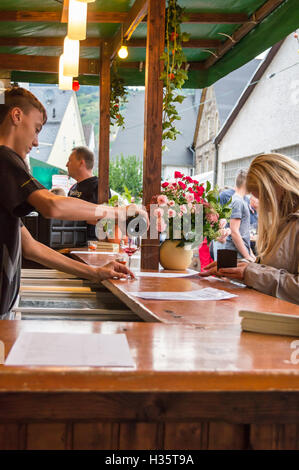 Ein Server, gießen ein Glas Rotwein an der Wolf Wein Straßenfest, Mosel, Rheinland-Pfalz, Deutschland Stockfoto