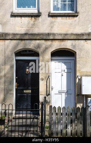 Zwei Haustüren ein in schwarz malen, der andere weiß lackierte. Stockfoto