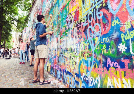 Junger Mann, der berühmte Lennon Graffiti Wandbemalung in der Altstadt von Prag, Tschechische Republik Stockfoto