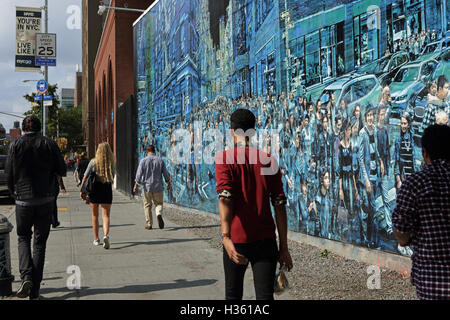 NYC Fußgänger gehen vorbei an einem großen Wandgemälde von Logan Hicks an der Bowery Wandbild Wand, Houston Street Stockfoto