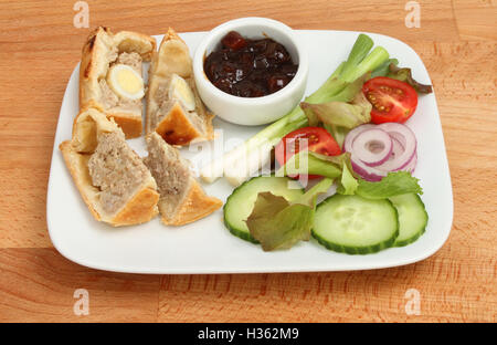 Scheiben von Wachteleier Ei Gala Kuchen und Salat auf einem Teller auf einer Tischplatte aus Buchenholz Stockfoto