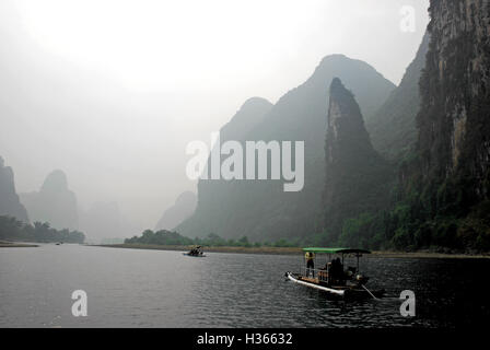 Passagiere genießen ein Bambus-Floßfahrt entlang der idyllischen Li-Fluss an einem nebligen Tag in Guangxi, China. Stockfoto