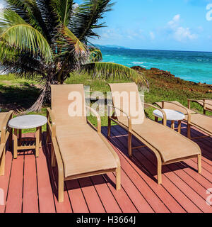 Sonnenliegen auf dem Deck von der Strandpromenade Tobago Karibik quadratische Komposition Stockfoto