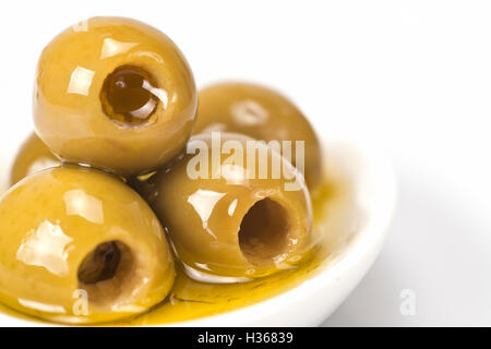 Entkernte Oliven in eine Untertasse isoliert auf einem weißen Hintergrund. Stockfoto