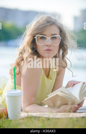 Romantisches Mädchen mit Buch im Citypark am Fluss-Ufer Stockfoto