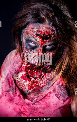 Porträt von Zombie-Mädchen starrte mit blutigen Make-up und Latex Prothese. Stockfoto