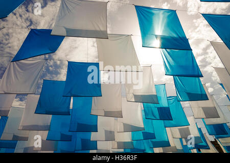 Blaue und weiße Fahnen gegen Sonne im Himmel. Stockfoto