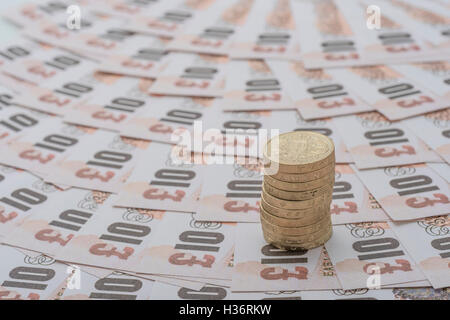 Aufgefächert altes Design £ 10 Banknoten mit Stapel alter Stil £ 1 Münzen - als visuelle Metapher für das Konzept der britischen Währung, Löhne, Wirtschaft und Inflation. Stockfoto