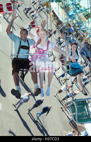 Paare, die Spaß auf Kette Karussell Ketten-Karussell auf dem Oktoberfest Stockfoto