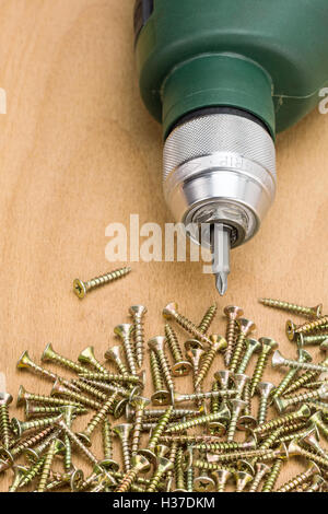 Bohrmaschine mit Schrauben auf Holz Hintergrund Stockfoto