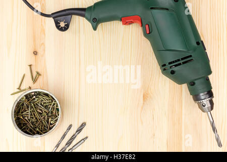 Bohrmaschine mit Schrauben auf Holz Hintergrund Stockfoto