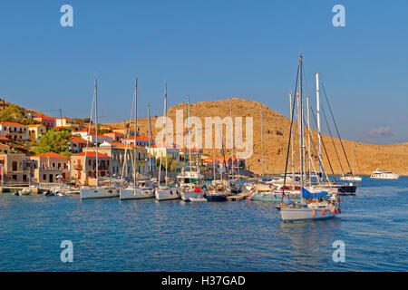 Private Segelyacht Ankunft am kleinen Jachthafen und Pontons in Chalki, Insel Chalki, Dodekanes, Griechenland. Stockfoto