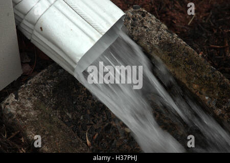 Regenwasser fließt vom Fallrohr Stockfoto