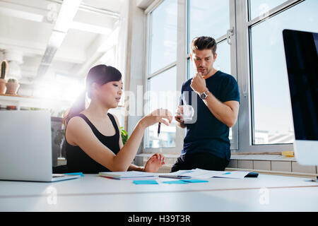 Aufnahme von zwei jungen Kollegen arbeiten in modernen Büros. Mitarbeiter Business Ideen zu diskutieren. Stockfoto