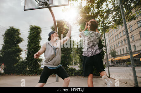 Zwei junge Männer Basketball gegeneinander spielen. Teenager Freunden eine Partie Basketball auf einen Freiplatz. Stockfoto