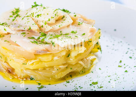 Gesalzener Kabeljau Fisch Ofen gebacken mit Kartoffeln, Zwiebeln und Olivenöl Stockfoto