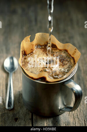 Gemahlenen Kaffee im Filterhalter auf hölzernen Hintergrund isoliert Stockfoto