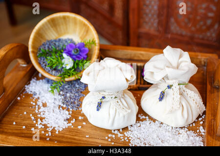 Stilleben, Taschen von Salz für Massage, mit Blumen, Kräuter im Spa. Stockfoto