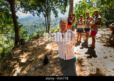 Indonesien, Lombok, Mataram, Pusuk Pass, Affenwald, Touristen, die Interaktion mit Affen Stockfoto