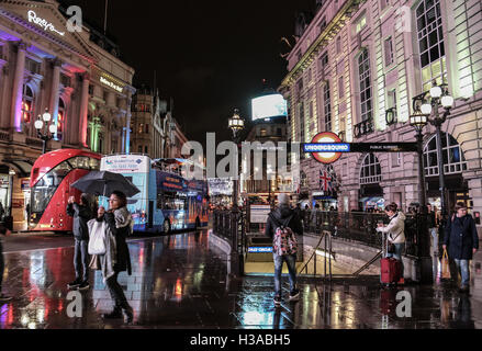 Fußgänger- und Autoverkehr am Piccadilly Circus in einer regnerischen Nacht in London, eines der pulsierenden Zentren der Stadt. Stockfoto