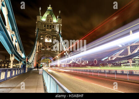 Langzeitbelichtung der helle Streifen verursacht durch einen Doppeldecker-Bus in der Nacht auf der berühmten London Bridge in London. Stockfoto