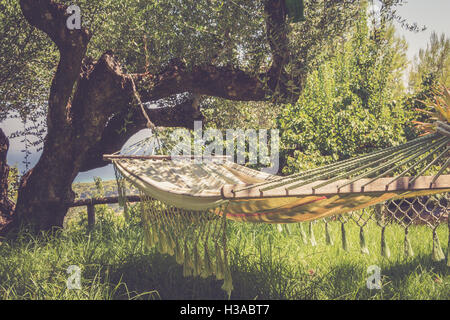 Zeit zum Faulenzen mit Hängematte im Sommergarten, Jahrgang getönt Stockfoto