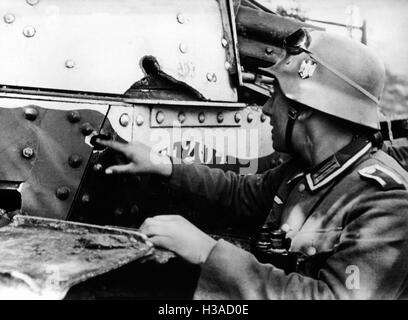 Deutscher Soldat inspiziert einen beschädigten Tank in Frankreich, 1940 Stockfoto