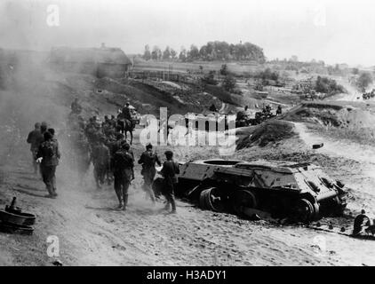 Deutsche Infanteristen gehen vorbei an abgeschossenen Panzer 1941 Stockfoto