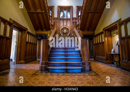 Eine hölzerne Treppe hinauf in den ersten Stock des Landhauses. Stockfoto