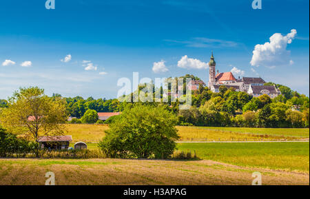 Schöne Aussicht auf die berühmte Andechs Abbey auf einem Hügel mit ländlichen bayerischen Landschaft an einem sonnigen Tag mit blauem Himmel und Wolken Stockfoto