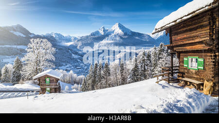 Winter Wunderland Bergkulisse der Alpen mit traditionellen Berghütten an einem kalten, sonnigen Tag Stockfoto