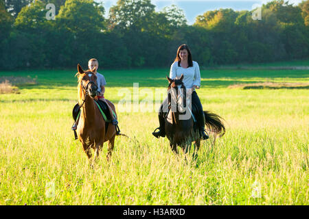 Reitstunden - Frau entlang ein Junge auf einem Pferd Reiten Stockfoto